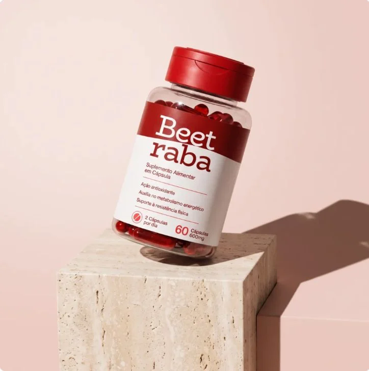 Pote transparente com tampa vermelha e rótulo branco e vermelho do suplemento BeetRaba, 60 cápsulas de 600 mg, sobre um bloco de pedra bege