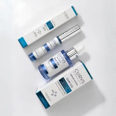 Kit CURVS BIOREGEN GHK-CU com caixa e frasco conta-gotas do sérum facial e caixa do gloss labial sobre fundo claro