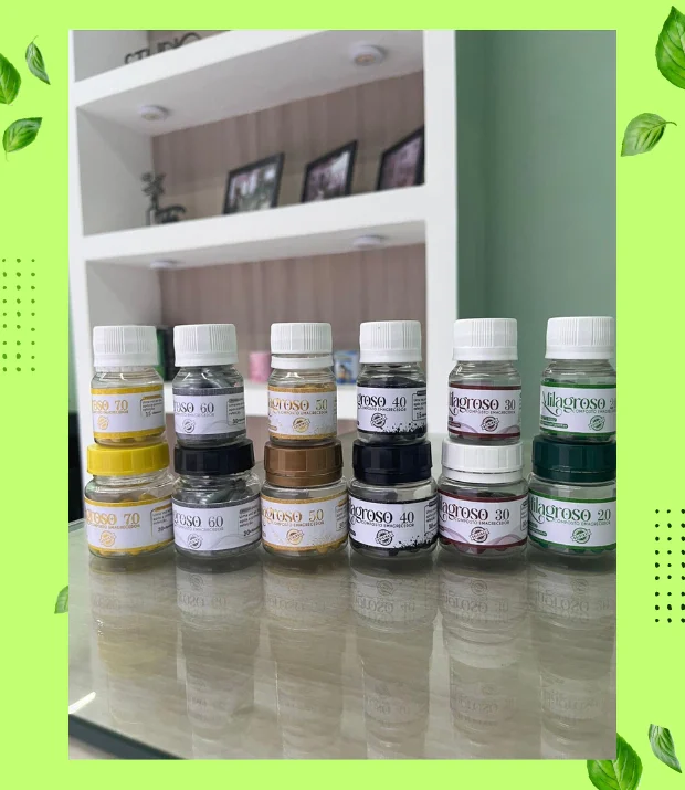 Seis potes de cápsulas da linha Milagroso, com tampas e rótulos em tons de amarelo, preto, dourado, bordô, cinza e verde, enfileirados em duas fileiras sobre uma bancada
